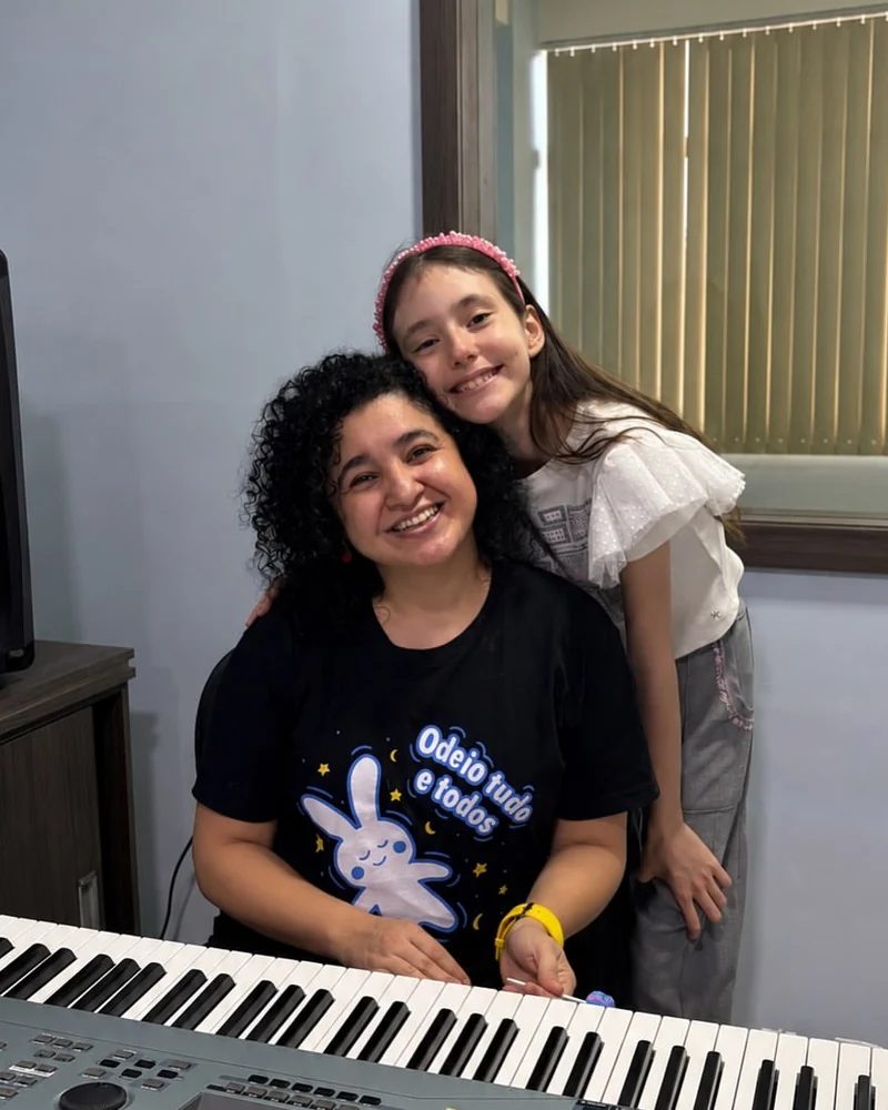 Professora e aluna ao teclado na Tocante Centro Musical